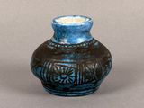 a blue vase sitting on a table with a brown background