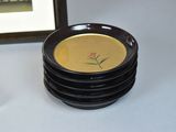 a plate with a flower on it next to a stack of plates