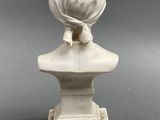 marble bust of a woman with a headscarf on a pedestal