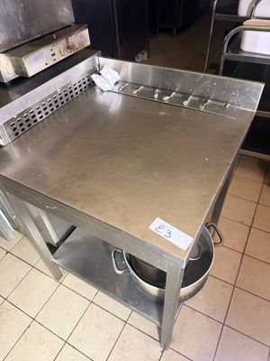 a stainless steel table in the middle of a kitchen