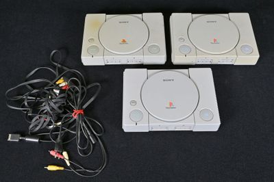 trois consoles de jeux vidéo posées les unes à côté des autres sur une table