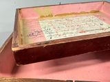 a pink box with writing on it and a knife in it