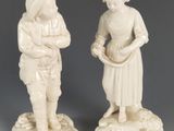 deux figurines d'un homme et d'une femme debout l'un à côté de l'autre