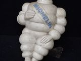 une petite statue représentant un homme avec une écharpe autour du cou