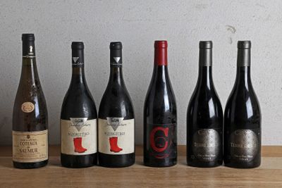 several bottles of wine are lined up on a wooden table