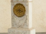 a white marble clock with a gold face on a table
