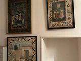 many pictures on the wall above a shelf in a room