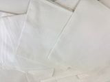 a pile of white napkins sitting on top of a bed