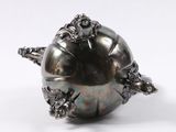an image of a close up of a silver object on a white surface