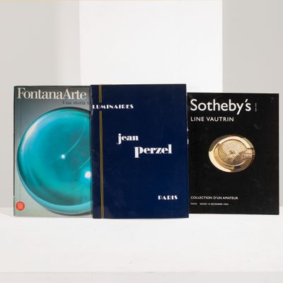 trois livres posés sur une étagère blanche, avec un bol bleu et une pièce d'or