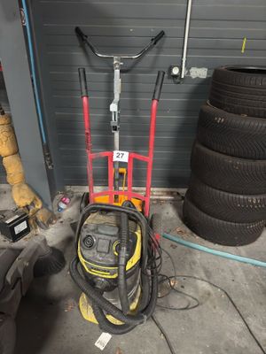 a yellow and red hand truck with a tire in the garage