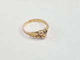 gros plan d'une bague en or sur une surface blanche