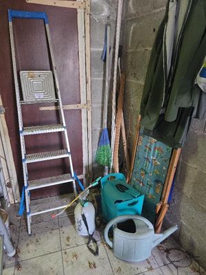 une photo d'une pièce avec une échelle, des toilettes et une poubelle