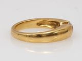 an image of a gold ring sitting on top of a white surface