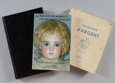 deux livres posés sur une table, avec une poupée à l'intérieur, et un livre posé sur la table