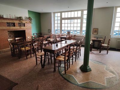 des tables et des chaises dans une pièce avec une cheminée au milieu