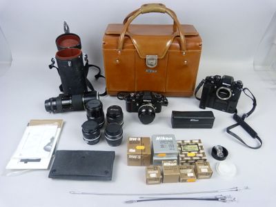 un sac en papier brun contenant un appareil photo et d'autres objets, posé sur une table