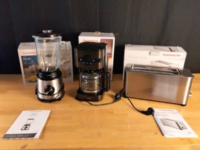 un mixeur, une cafetière, un grille-pain et un grille-pain posés sur une table