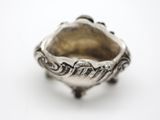 a close up of a silver ring on a white surface