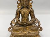 une statue en laiton représentant un Bouddha assis en position du lotus