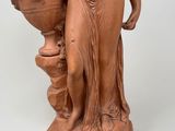 statue of a woman holding a vase and a vase on a pedestal