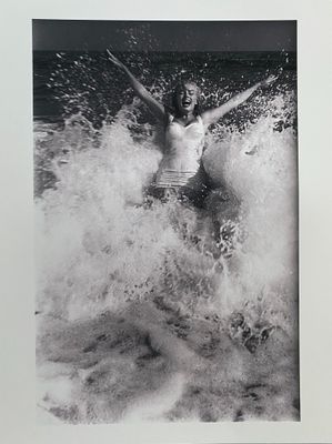 black and white photograph of a woman in a bathing suit in the ocean