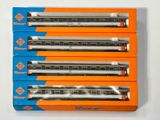 quatre wagons fermés sont alignés sur une surface blanche