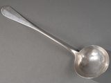 une cuillère en argent avec un manche de cuillère sur une table