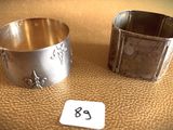 pair of silverplated napkin holders with numbers on them on a table