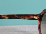 sunglasses with a tortoise shell frame on a white surface