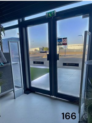 a picture of a large glass door with a sign on it