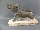 bronze statue of a dog on a stone base on a gray background