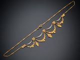 un collier en or et en argent orné de feuilles sur fond noir