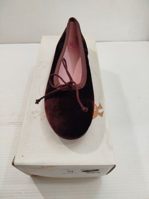 quelqu'un porte une paire de chaussures posées sur une boîte