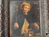 un vieux tableau représentant un homme tenant un bâton, dans un cadre en bois