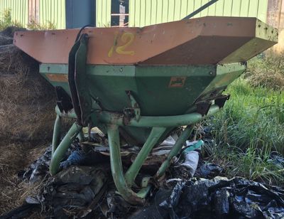 a green and brown wheelbarrower sitting in a pile of trash