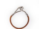 un gros plan d'un bracelet en cuir marron sur fond blanc