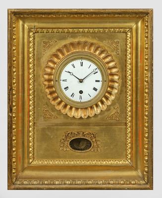 un cadre doré avec une horloge accroché au mur