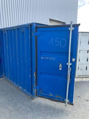un conteneur bleu posé à l'extérieur d'un immeuble