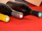 three bottles of wine sitting on a red table