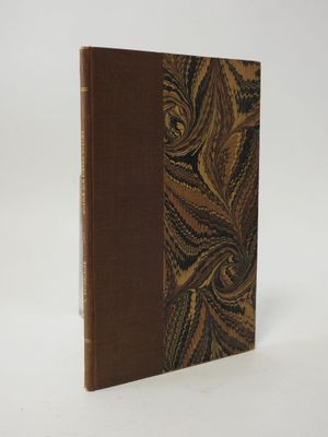 an old book with a brown cover sitting on top of a white surface