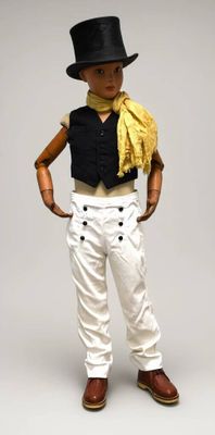 une poupée qui porte un haut-de-forme et un pantalon blanc