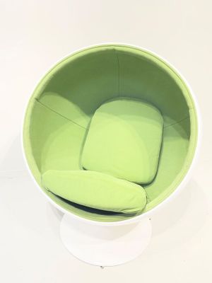 une chaise verte posée sur un socle blanc