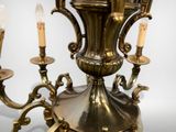 a large brass chandelier with three candles on it