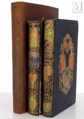 two old books sitting on top of each other on a table