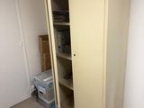 a closet in the corner of a room with a door open