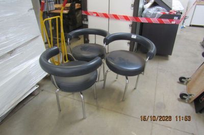 trois chaises posées à même le sol dans un entrepôt