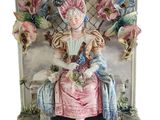 a figurine of a woman sitting on a bench