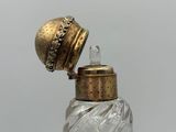 a small glass bottle with a gold cap on it