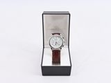 a close up of a watch in a box on a white surface